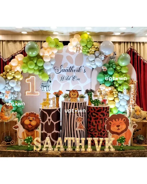 A classic "Wild One" jungle theme for Saathvik's first birthday, complete with animal cutouts and print-themed pedestals.