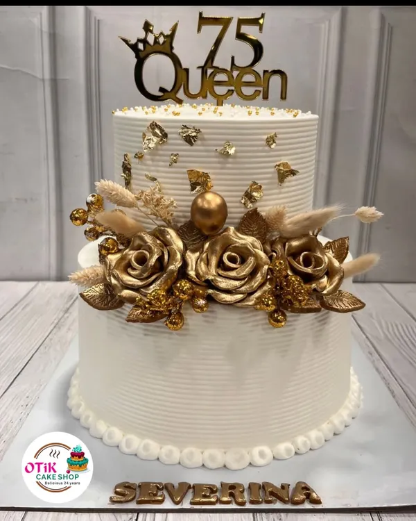 We designed this stunning two-tiered cake to celebrate a 75th birthday. The clean white buttercream is adorned with beautiful golden roses and a "75 Queen" topper, making it a truly regal centerpiece.