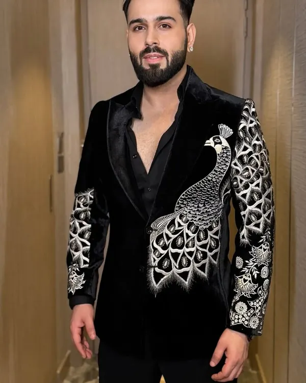 A stunning example of motif work, this black velvet tuxedo jacket features a large, beautifully detailed peacock embroidered across the front and sleeve. The silver threadwork creates a striking contrast.