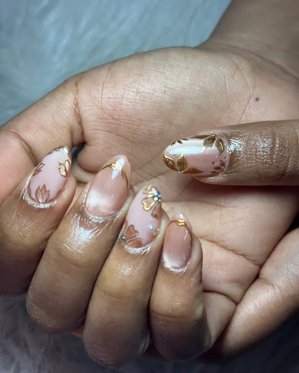 A close-up of a beautiful bridal set. The design features a soft cat eye effect on a nude base, with delicate gold floral details and tiny rhinestones that sparkle perfectly.