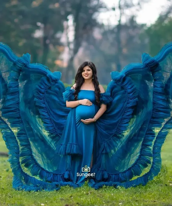 A breathtaking outdoor shot where we used fabric tossing to create a butterfly-wing effect with this vibrant blue gown. The lush greenery of the park provides a stunning contrast.