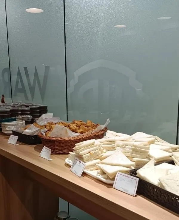 A high-tea spread for Warner Bros Discovery, featuring classic sandwiches, savory bites in wicker baskets, and desserts. Perfect for casual meetings or corporate mixers.