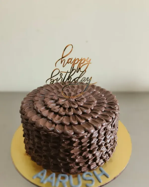 A rich chocolate truffle cake with a beautiful textured petal effect, created using a palette knife.