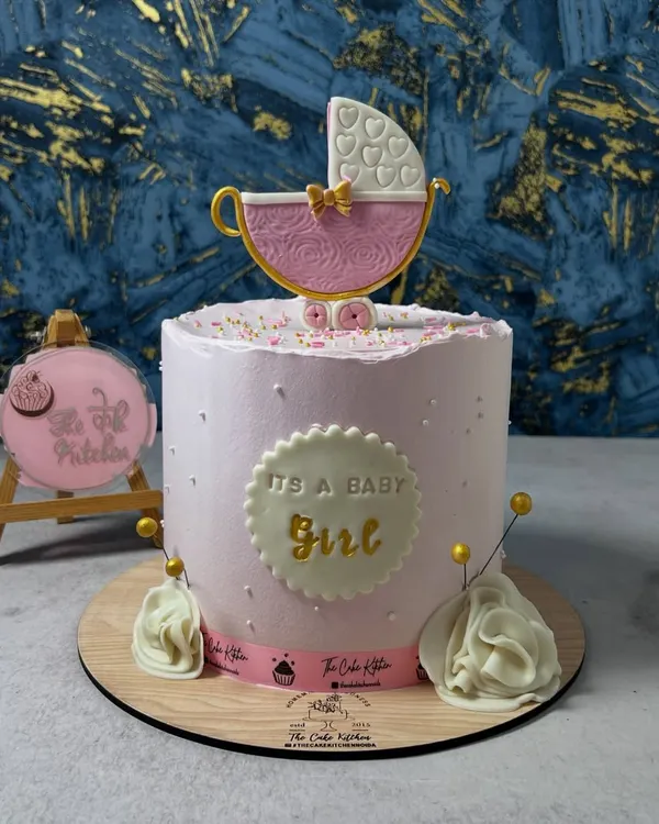 A beautiful "It's a Baby Girl" cake for a baby shower. This pink buttercream cake is topped with an intricate, handcrafted sugar pram.