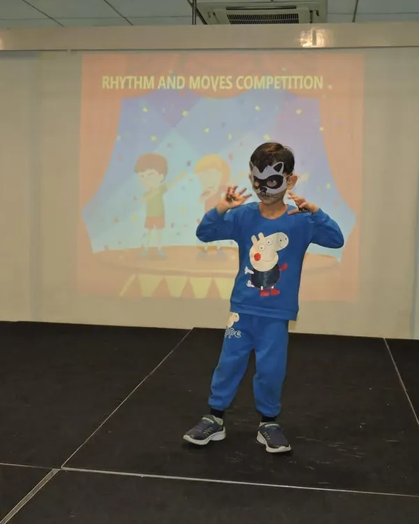 A young performer strikes a pose during our "Rhythm and Moves" competition. We encourage every child to step onto the stage, helping them build confidence and discover the joy of dance.