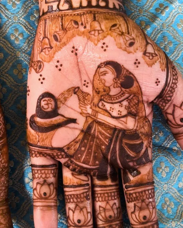 A close-up of a divine Shiva-Parvati portrait on the palm. This is a beautiful way to incorporate spiritual elements into your bridal henna.
