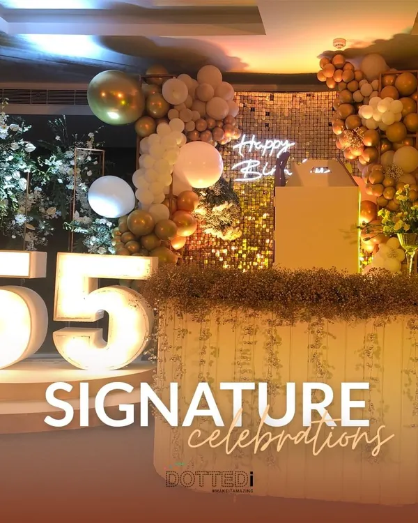 A glamorous setup for a 55th birthday, which I call my "Signature Celebrations." The decor features large marquee numbers, a gold sequin backdrop, and elegant balloon arrangements.