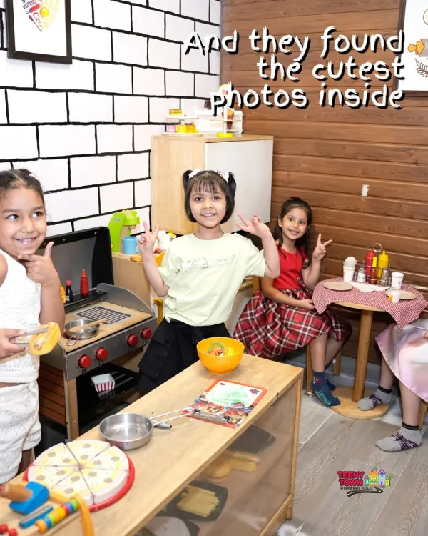 Girls having a blast in the pretend-play kitchen during a Frozen-themed party.