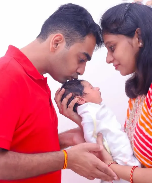 A father's gentle kiss on his newborn's head. We focus on these quiet, intimate connections during our lifestyle newborn sessions.