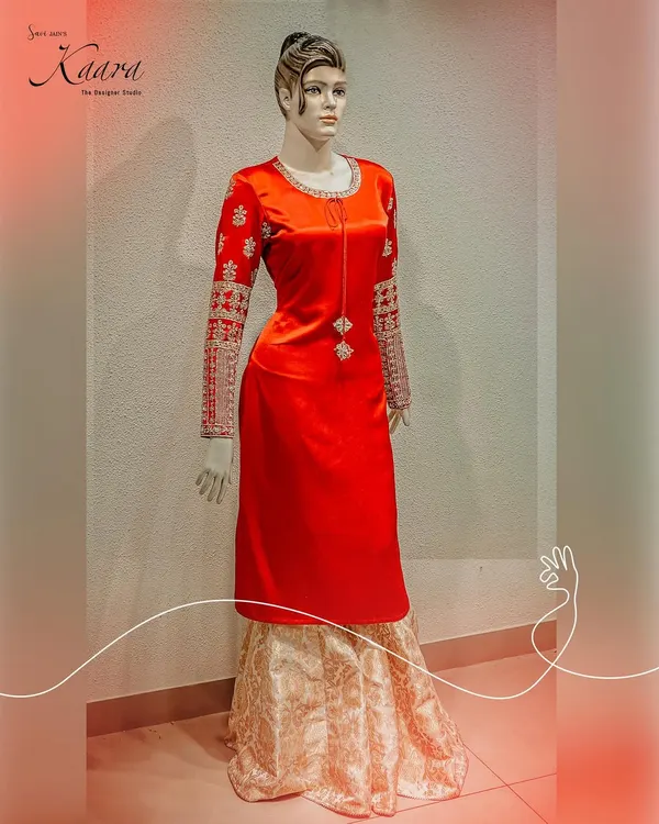 A statement in red. This long velvet kurta is paired with a classic brocade skirt, creating a regal and timeless look. The sleeves are heavily embroidered with intricate zardosi work, adding a touch of luxury.