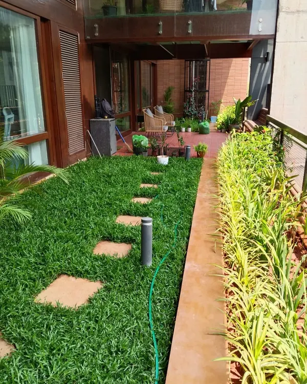 I believe every space, no matter the size, holds the potential for a green sanctuary. Here, we turned a narrow patch into a lush lawn with a clean pathway, creating a serene walkway that instantly elevates the home's exterior. This is what I love to do: find beauty in every corner.