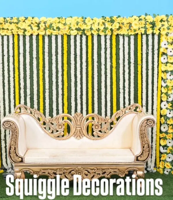 A traditional baby shower stage with a backdrop of jasmine and yellow flower garlands.