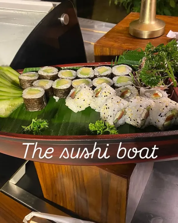 We bring authentic global flavors to your event, like this beautifully arranged sushi boat. It's a perfect example of our Pan-Asian offerings, featuring a variety of fresh sushi and maki rolls presented as a culinary centerpiece.