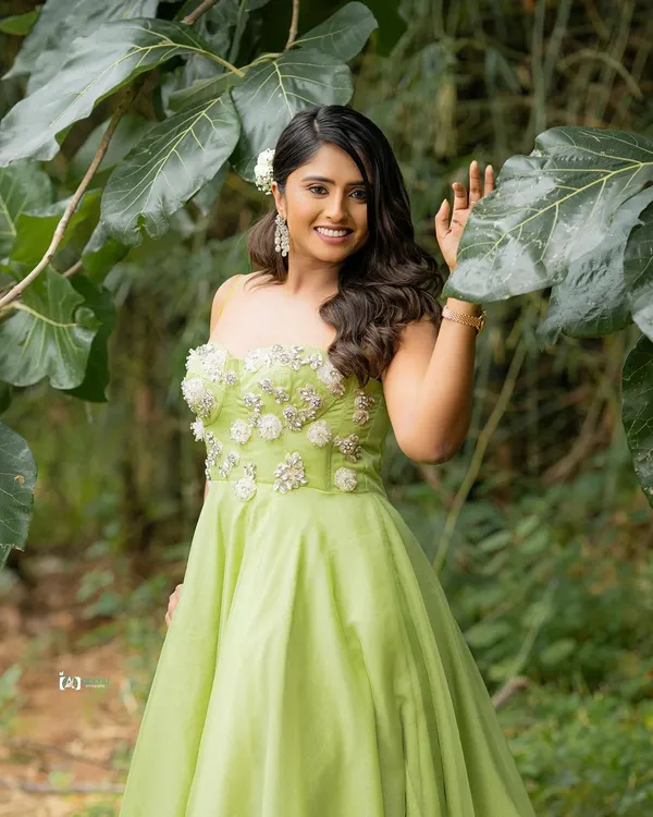 The vibrant lime green dress pops against the lush green foliage. This outdoor portrait uses natural light to create a fresh, bright, and joyful image.