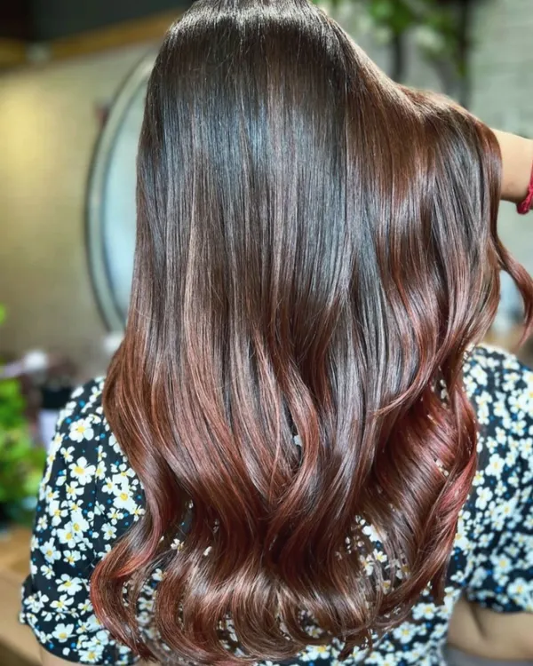 A stunning copper touch balayage. The warm, rich copper tones are hand-painted onto the hair to create a seamless blend with the darker base, adding warmth and vibrancy.