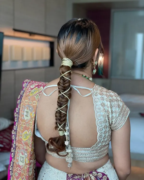 A detailed shot of a gotta string fishtail braid. This hairstyle is a modern twist on a traditional element, perfect for a Haldi or Mehendi ceremony to complement a vibrant outfit.