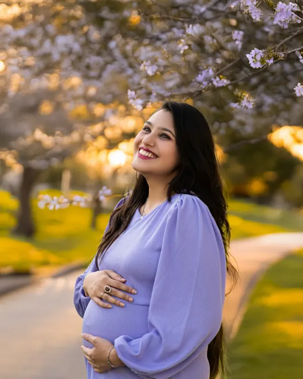 Pure joy captured during a golden hour photoshoot. The beautiful backlighting and blooming trees create a magical atmosphere for this radiant mother-to-be.