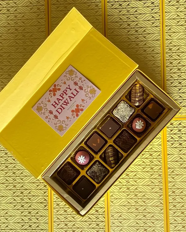 My luxury Diwali gift box, filled with an assortment of handcrafted truffles and fusion sweets. The vibrant yellow packaging and festive card make it a perfect gift for corporate clients or loved ones.