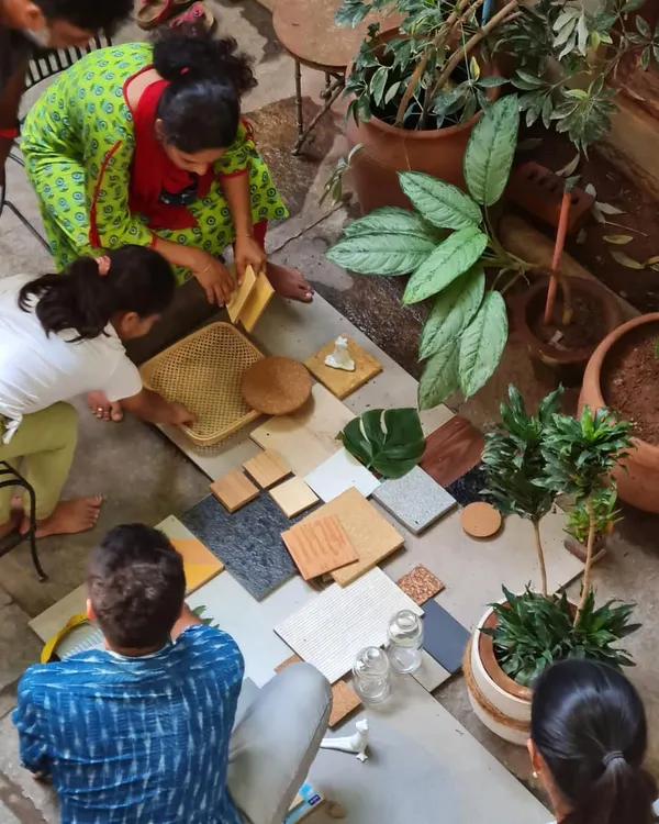 Our design process is very hands-on. Here, our team and clients are gathered in the studio courtyard, physically arranging material samples to create the perfect palette of colors and textures for their home.
