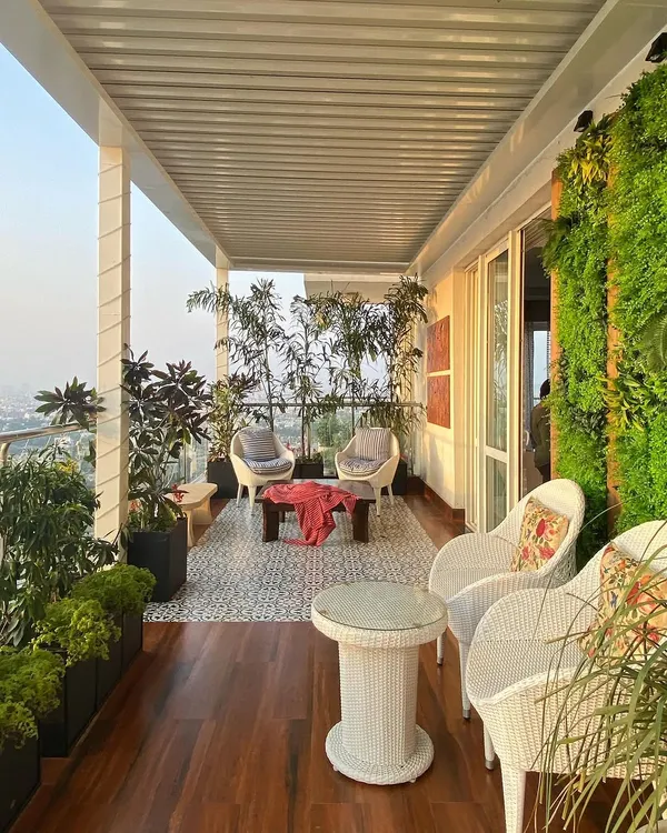 We transformed this Gurgaon high-rise terrace into a complete outdoor living area. This view shows how we combine different zones, using rich hardwood decking for the main path, patterned tiles for the seating area, and a lush vertical garden wall to bring in vibrant greenery.