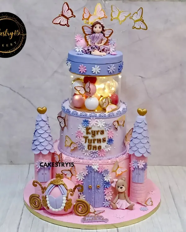 This two-tier chocolate ganache cake transforms a birthday into a royal ball. We designed it as a fairytale castle, complete with towers, a rotating top tier with a doll, and a magical illuminated spacer that brings the entire creation to life.