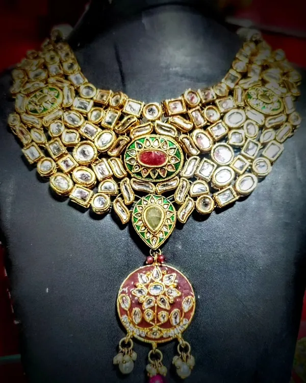 This stunning Polki wedding necklace is the epitome of royal elegance. Crafted by artisans from Bikaner, it features intricate details and uncut stones that give it an authentic, heirloom quality, perfect for your most special occasions.