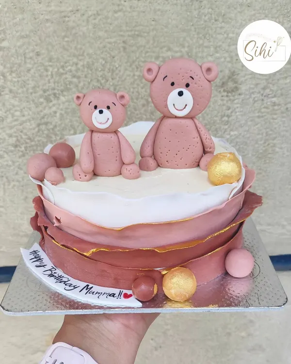 From a daughter to her mama bear. This sweet cake features two fondant teddy bears and a modern, layered chocolate wrap design in dusty rose tones.