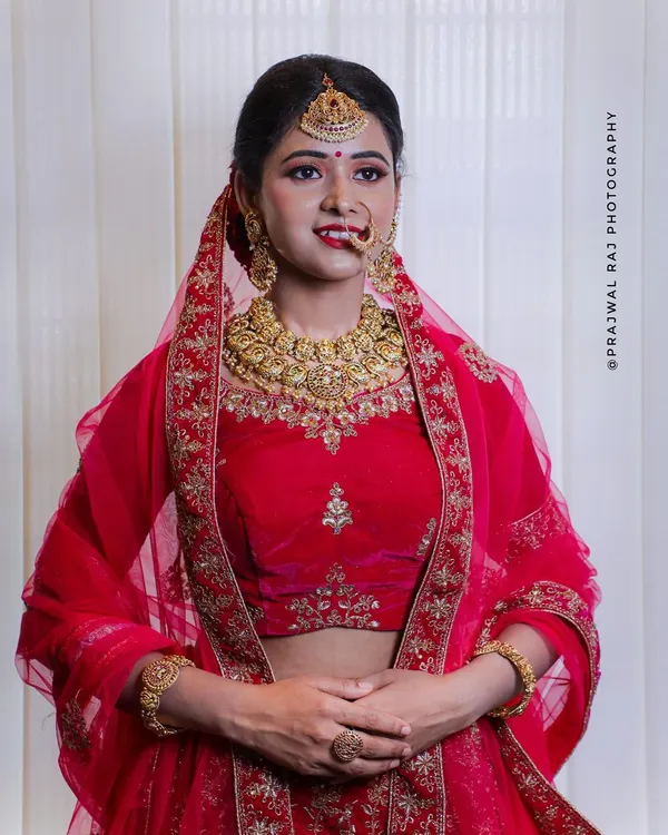 This classic red bridal lehenga is perfect for a traditional wedding ceremony. It features heavy gold embroidery on a rich fabric and comes as a complete set, available for rent in Bangalore.