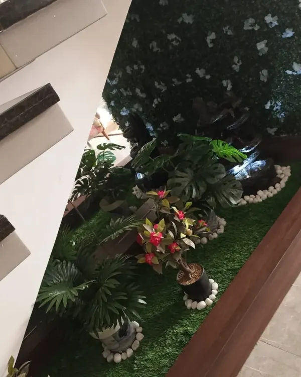 I transformed the unused space under a modern staircase into a small indoor garden. The project included artificial grass, a vertical plant wall, and decorative potted plants.