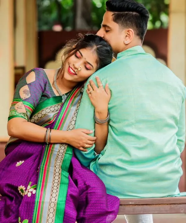 A simple, heartfelt moment on a traditional swing. Her beautiful purple saree and the rustic architectural backdrop come together to create an image that is rich in cultural elegance and emotion.