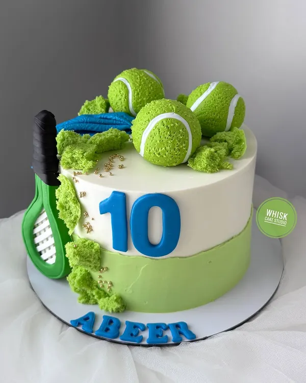 A cake for a lawn tennis player. This sporty design features a tennis racket, edible tennis balls, and a vibrant green and white color scheme.