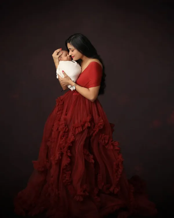 This is the moment I strive to capture: the overwhelming love and tenderness as a mother holds her new world in her arms. This portrait, using one of the beautiful gowns from my studio wardrobe, is all about elegance and pure emotion.