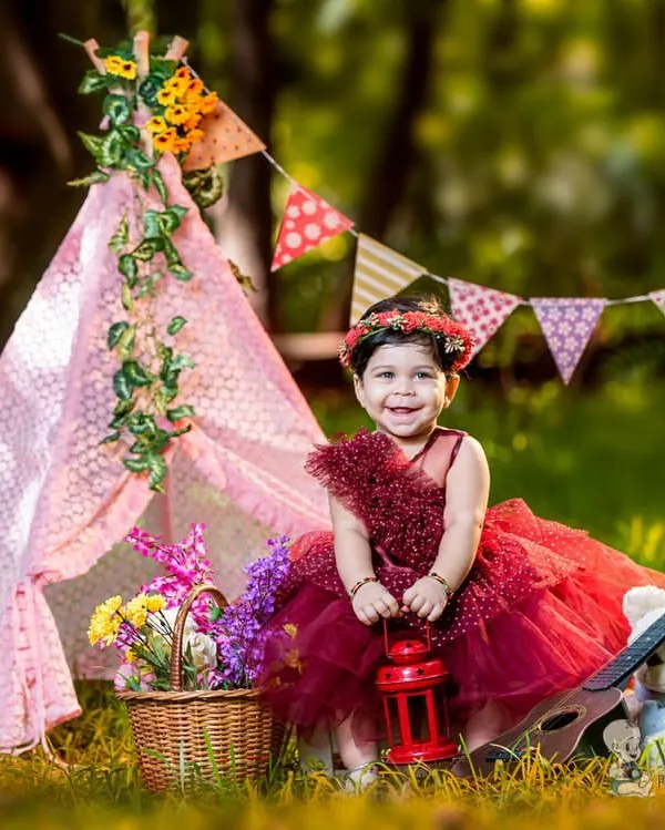 A beautiful outdoor portrait with one of my favorite props, a pink teepee. The natural light and green surroundings create a perfect setting for this little girl in her lovely red dress.