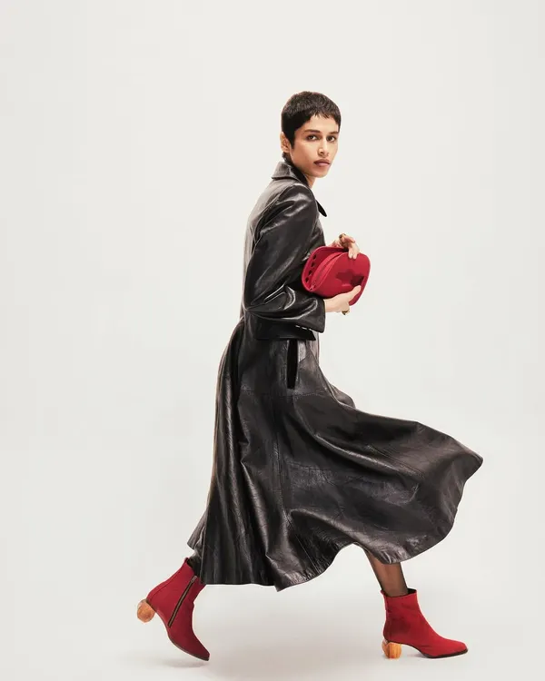 Creative direction for the footwear brand Disobedience. The model is captured mid-stride in a vintage Loewe leather look, showcasing the red boots in a dynamic, editorial style.