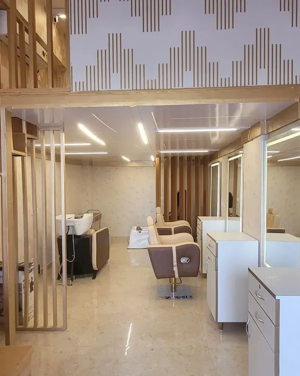 An inside look at our salon's layout, featuring our comfortable styling chairs, backwash stations for a relaxing head massage, and brightly lit mirrors. The space is designed for both functionality and comfort.