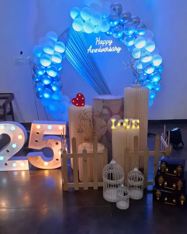 A stunning silver jubilee celebration for a 25th anniversary. I used a blue and silver color scheme, a circular backdrop with draping, and large marquee numbers to mark this incredible milestone.