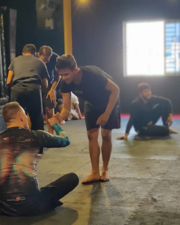 A moment of respect and connection as a student shakes hands with visiting Professor Bernd Roeske after a roll.