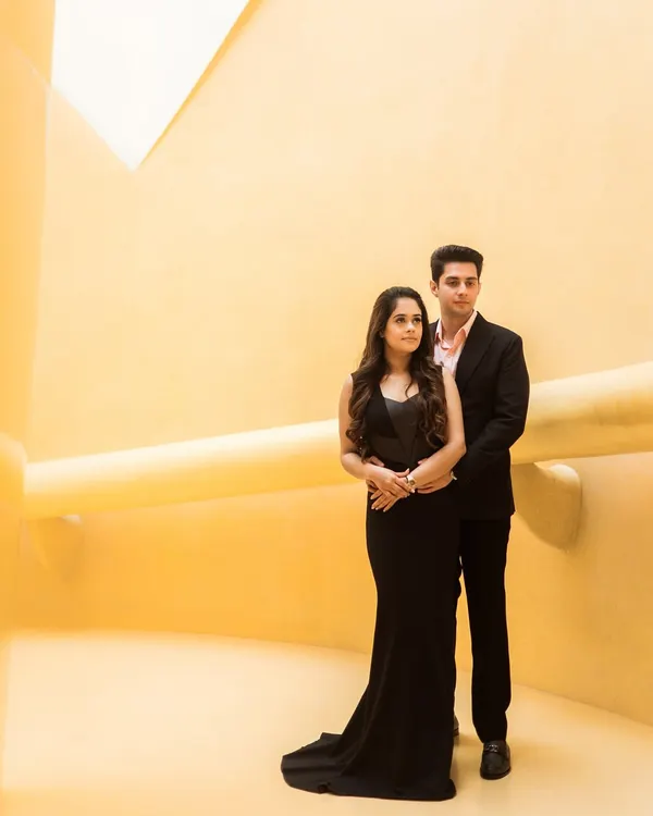 A perfect example of modern minimalism. The couple's classic black attire stands out against the bold, yellow architectural lines, creating a portrait that is both striking and sophisticated.