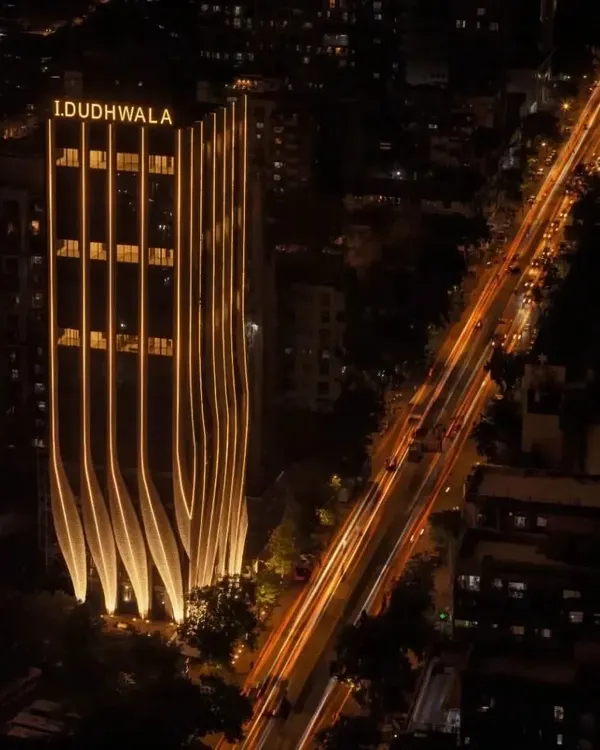 The illuminated facade of ID Origins in Mumbai creates a powerful visual statement at night. The undulating calligraphic strokes are highlighted, transforming the building into a beacon and a landmark for the surrounding 12-acre site.