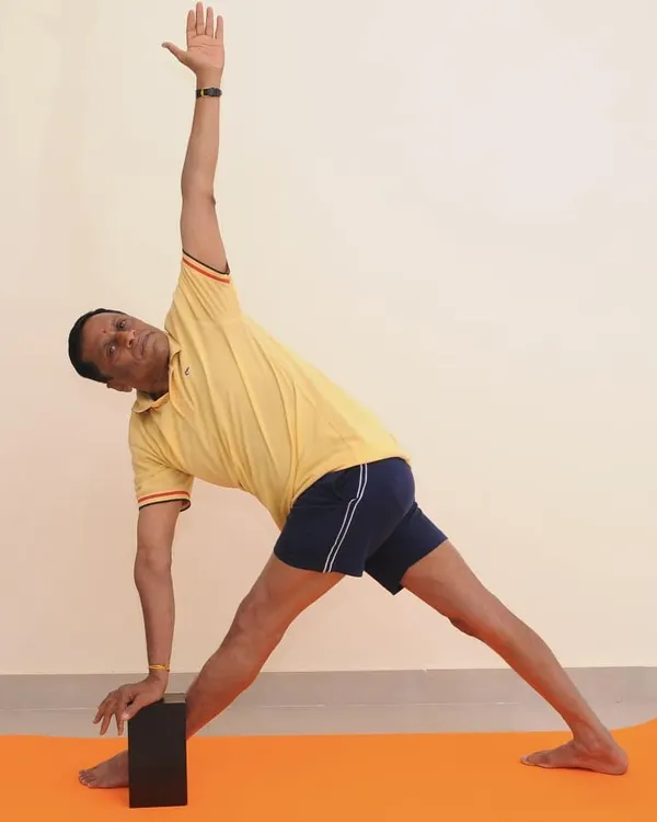 Parivrtta Trikonasana (Revolved Triangle Pose). This standing twist requires balance, hamstring flexibility, and spinal rotation. The block under the hand helps to keep the spine long.