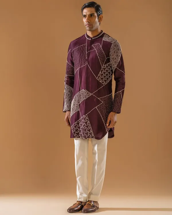 A deep plum kurta featuring modern, geometric threadwork. This piece reflects the finesse of artisanal craftsmanship and the quiet confidence of the modern gentleman, tailored to perfection.
