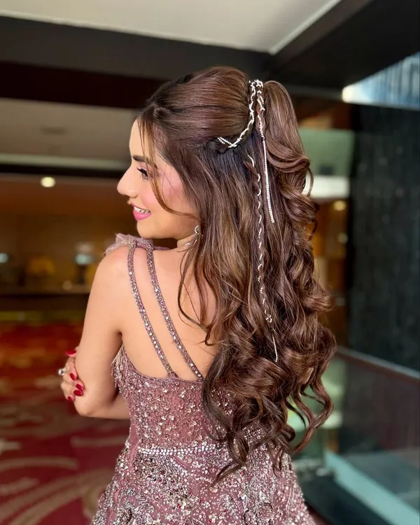 A high-glam ponytail with voluminous curls, perfect for a cocktail or sangeet night. I added a delicate silver braid wrap to give this fun style an extra touch of sparkle.