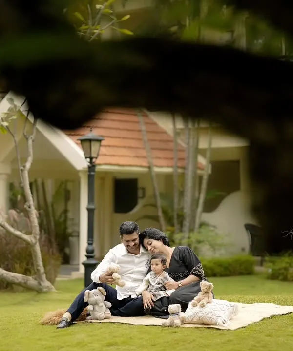 A relaxed family picnic on a beautiful green lawn. This type of outdoor family portrait session is perfect for capturing genuine interactions in a natural setting.