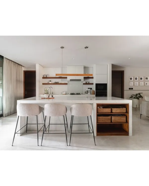 The heart of this home is the open-plan kitchen and dining area. A large marble island with bar stools serves as a casual spot for breakfast and conversation, connecting directly to the more formal dining space.