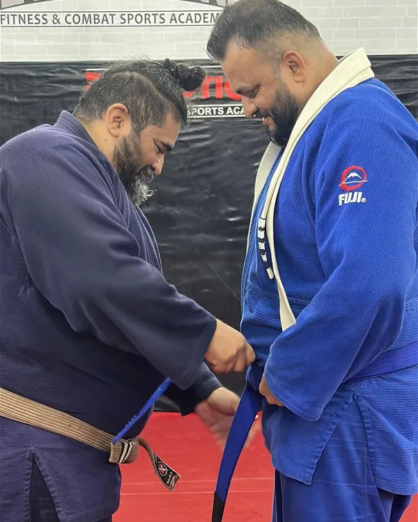 Level up. The moment a student earns their blue belt in Brazilian Jiu-Jitsu. This is a significant milestone, representing countless hours of dedication and learning on the mats.