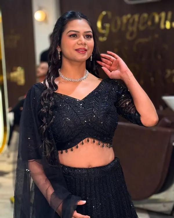 A perfect example of modern party makeup. This look features a flawless HD base, subtly defined eyes, and a natural lip color, allowing her sparkling black lehenga to shine. It's chic, elegant, and perfect for any celebration.