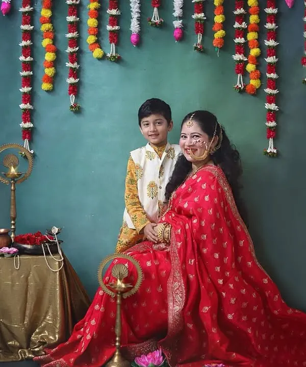 Celebrating tradition and motherhood with this stunning mom to be and her son. The rich red saree and festive backdrop with marigold flowers create such a warm and vibrant maternity portrait.