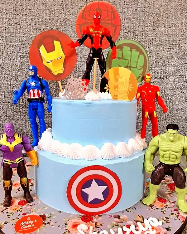 This two-tier Avengers theme cake is a huge hit for kids' birthday parties. It features popular superhero figurines like the Hulk, Captain America, and Iron Man, all assembled to create an action-packed centerpiece for your little one's special day.