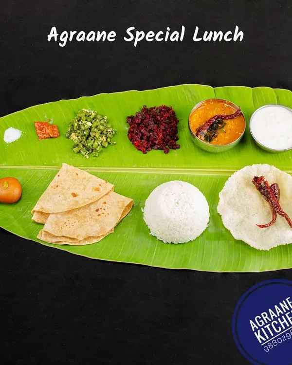 This is our Agraane Special Lunch, a complete Brahmin-style meal served on a traditional banana leaf. It includes chapati, white rice, sambar, a vegetable stir-fry (palya), kosambari, pickle, curd, and a sweet, giving you the authentic taste of a home-cooked feast.