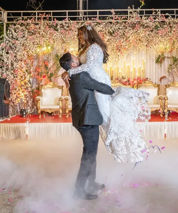A truly magical first dance. The groom lifts his bride against a backdrop of sparklers and smoke, creating a cinematic moment that feels straight out of a movie. This is what I mean by an epic wedding reception.